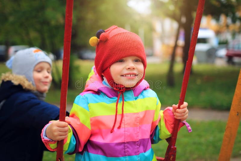 Les petits enfants heureux se roulent sur l'oscillation Enfants jouant sur le carrousel Cour de jeu 2 d'enfants images libres de droits Les petits enfants heureux se roulent sur l'oscillation Enfants jouant sur le carrousel Cour de jeu 2 d'enfants images libres de droits
