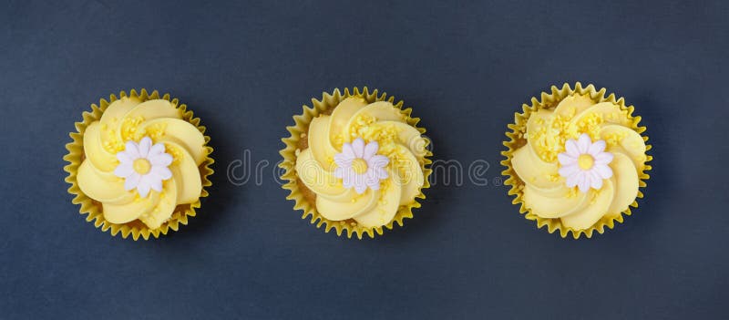 Les petits gâteaux de citron avec le remous et le fondant de crème de beurre fleurissent la décoration photo libre de droits Les petits gâteaux de citron avec le remous et le fondant de crème de beurre fleurissent la décoration photo libre de droits