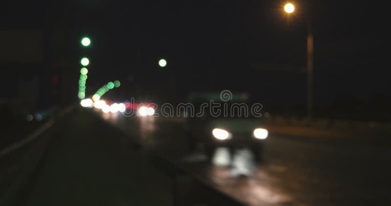 Les phares et les lumières Defocused de queue du trafic de approche de route brillent pendant l'heure de pointe Nuit tirée du pas