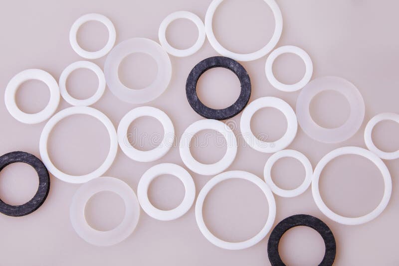 White and black hydraulic and pneumatic o-ring seals of different sizes scattered a white background. Rubber rings. Sealing gaskets for hydraulic joints. Rubber sealing rings for plumbing. Top view. White and black hydraulic and pneumatic o-ring seals of different sizes scattered a white background. Rubber rings. Sealing gaskets for hydraulic joints. Rubber sealing rings for plumbing. Top view