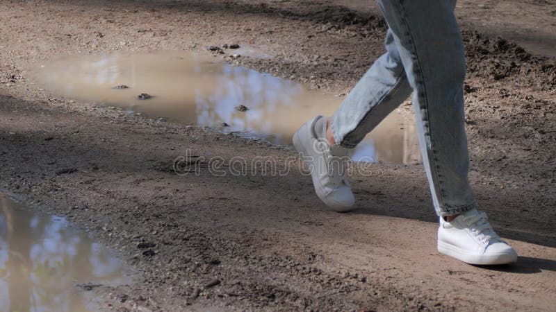 Les Pieds Des Femmes Marchant Dans La Rue Boueuse à Travers Des Boules Et  La Boue Pas De Routes Concept Clips Vidéos - Vidéo du normal, nature:  221282271