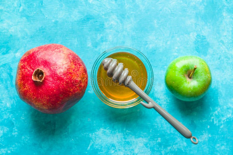 Les pommes, la grenade et le miel sur une turquoise ajournent la ligne image libre de droits Les pommes, la grenade et le miel sur une turquoise ajournent la ligne image libre de droits