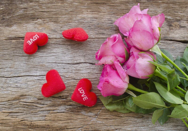 Les roses et le coeur rouge se reposent sur le vieux panneau en bois, le jour de valentines b photo libre de droits Les roses et le coeur rouge se reposent sur le vieux panneau en bois, le jour de valentines b photo libre de droits