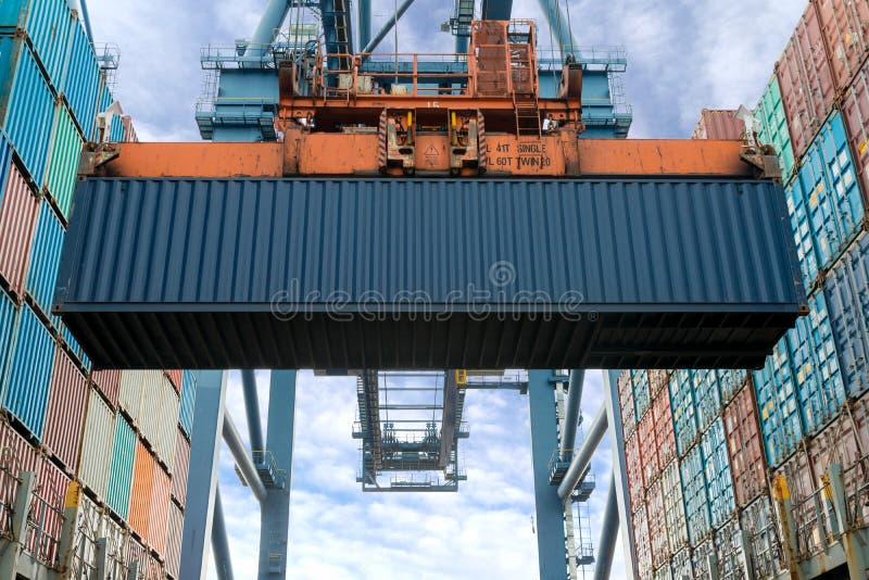 Les récipients industriels de chargement de grue dans un fret de cargaison se transportent escroc image stock Les récipients industriels de chargement de grue dans un fret de cargaison se transportent escroc image stock