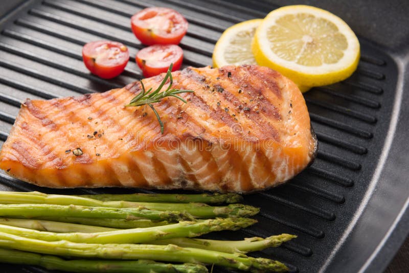 Les saumons grillés ont fait cuire le BBQ sur une casserole sur le fond en bois image stock Les saumons grillés ont fait cuire le BBQ sur une casserole sur le fond en bois image stock