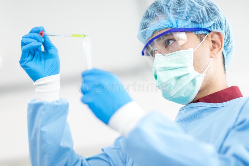 Asian scientists wear protective clothing while doing medical research in a science lab. Asian scientists wear protective clothing while doing medical research in a science lab