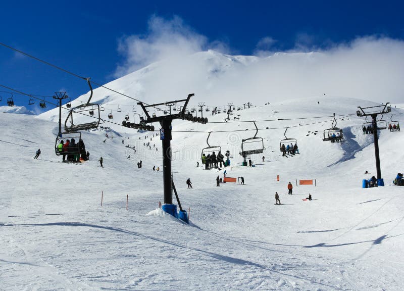 Les skieurs, les surfeurs et le touriste voyageant dans des funiculaires dans une neige ont couvert la montagne brumeuse photographie stock Les skieurs, les surfeurs et le touriste voyageant dans des funiculaires dans une neige ont couvert la montagne brumeuse photographie stock