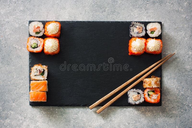 Les sushi assortis ont servi sur une ardoise en pierre noire photographie stock libre de droits Les sushi assortis ont servi sur une ardoise en pierre noire photographie stock libre de droits