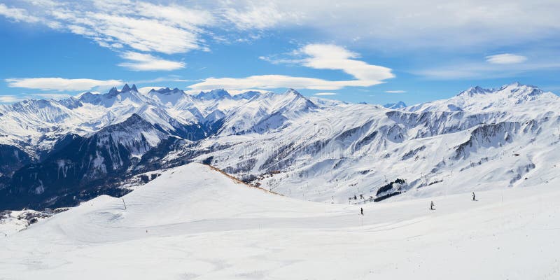 Les Sybelles ski slopes and surrounding white mountain peaks, on a sunny Winter day - panorama in the French alps royalty free stock photo Les Sybelles ski slopes and surrounding white mountain peaks, on a sunny Winter day - panorama in the French alps royalty free stock photo