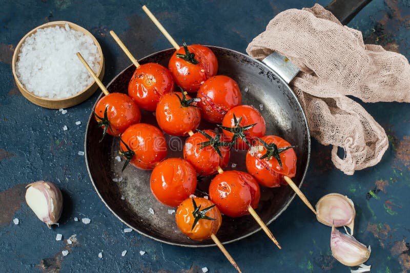 Les tomates ont grillé sur des brochettes avec l'huile d'olive, ail, sel images stock Les tomates ont grillé sur des brochettes avec l'huile d'olive, ail, sel images stock