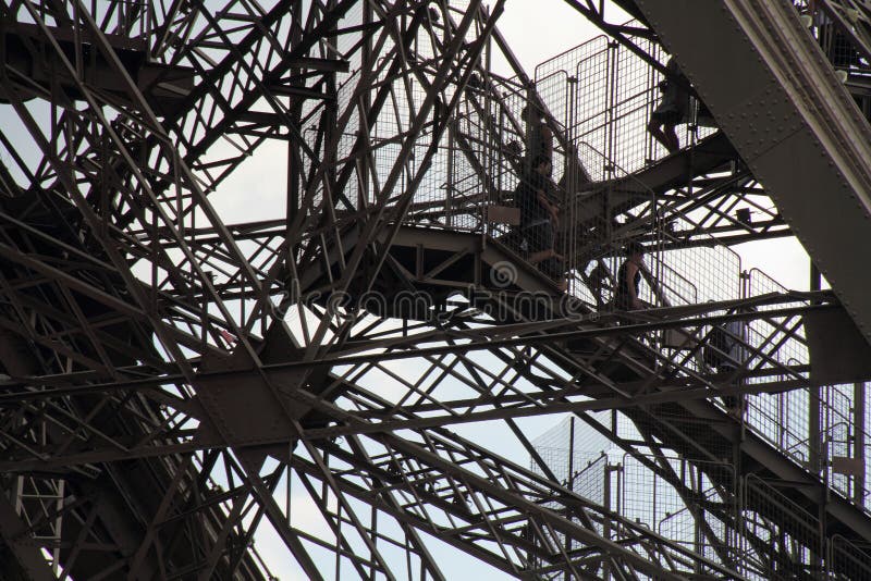 Tourists walk down the Eiffel Tower. Tourists walk down the Eiffel Tower