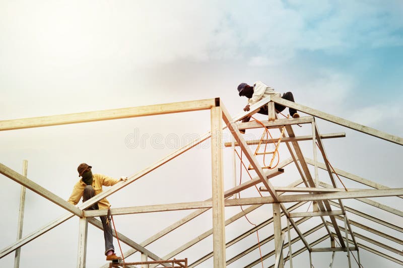 Les travailleurs d'hommes sur la construction en acier de toit structurent l'industrie avec images stock Les travailleurs d'hommes sur la construction en acier de toit structurent l'industrie avec images stock