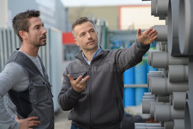 Les tuyaux d'acier dicussing d'aboout de directeur entourent le tuyau dans l'usine photos libres de droits Les tuyaux d'acier dicussing d'aboout de directeur entourent le tuyau dans l'usine photos libres de droits