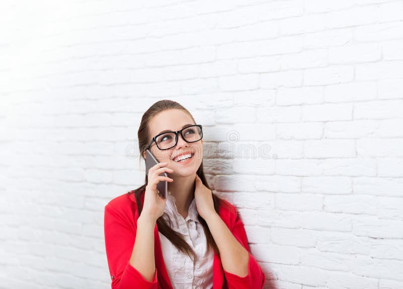 Les verres rouges de veste de sourire de femme d'affaires de téléphone portable d'appel téléphonique d'usage heureux de problème photos libres de droits Les verres rouges de veste de sourire de femme d'affaires de téléphone portable d'appel téléphonique d'usage heureux de problème photos libres de droits