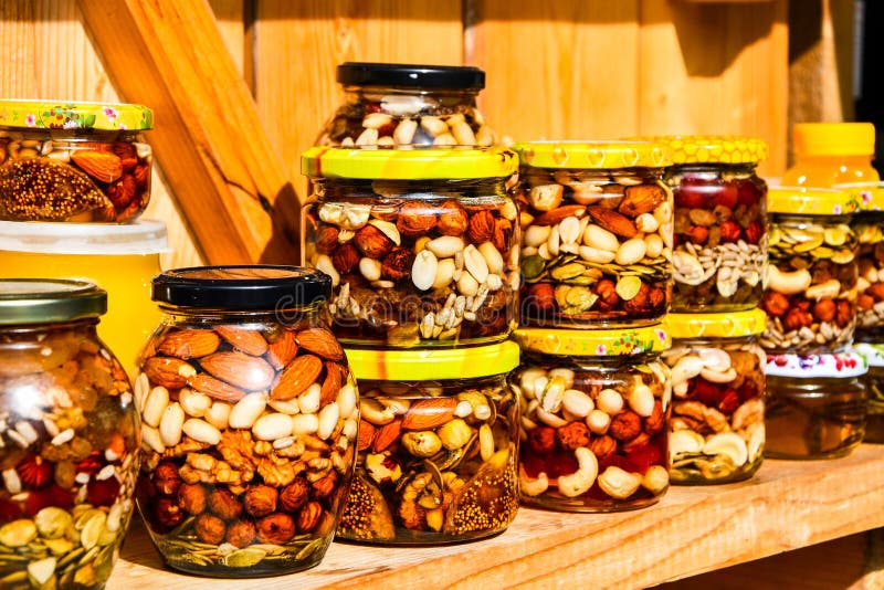 Les vitamines délicieux sont remplies de miel et discothèques naturels sur les étagères. Noix et cacahuètes dans un bocal rempli de sirop de miel. Compteur de miel avec des écrous