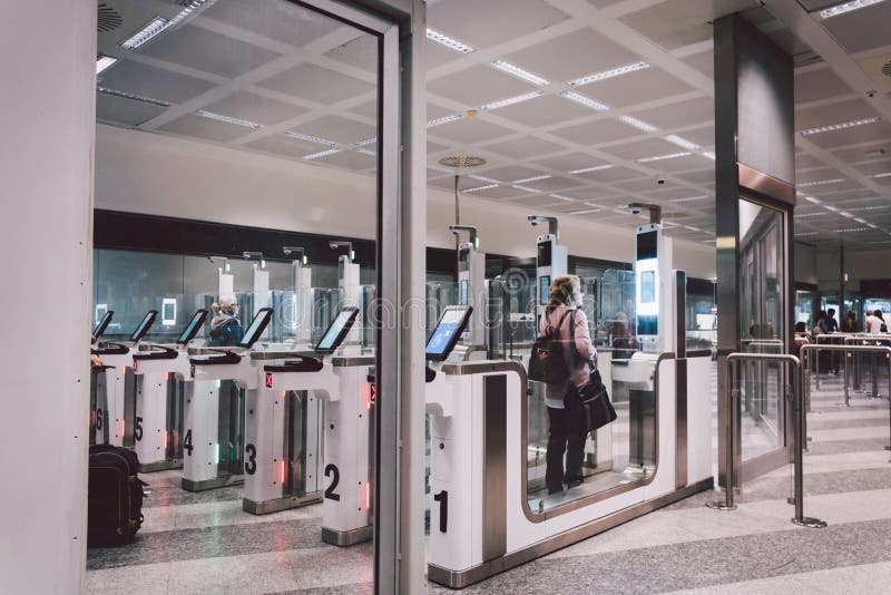 Les voyageurs aériens passent par les portes automatiques de contrôle des frontières de l'aéroport de Milano Malpensa Vérificatio image stock Les voyageurs aériens passent par les portes automatiques de contrôle des frontières de l'aéroport de Milano Malpensa Vérificatio image stock
