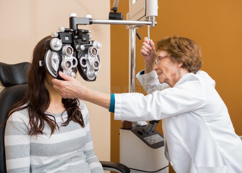 Les yeux d'Examining Young Woman d'optométriste image stock Les yeux d'Examining Young Woman d'optométriste image stock