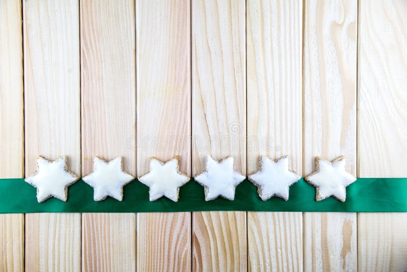 Les étoiles délicieuses de cannelle se trouvent sur un ruban vert photos stock Les étoiles délicieuses de cannelle se trouvent sur un ruban vert photos stock