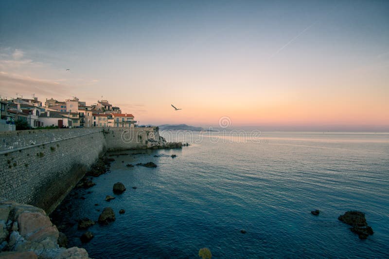 Les Антиба Хуана прикалывают побережье Средиземного моря во время сумерк, голубого захода солнца часа