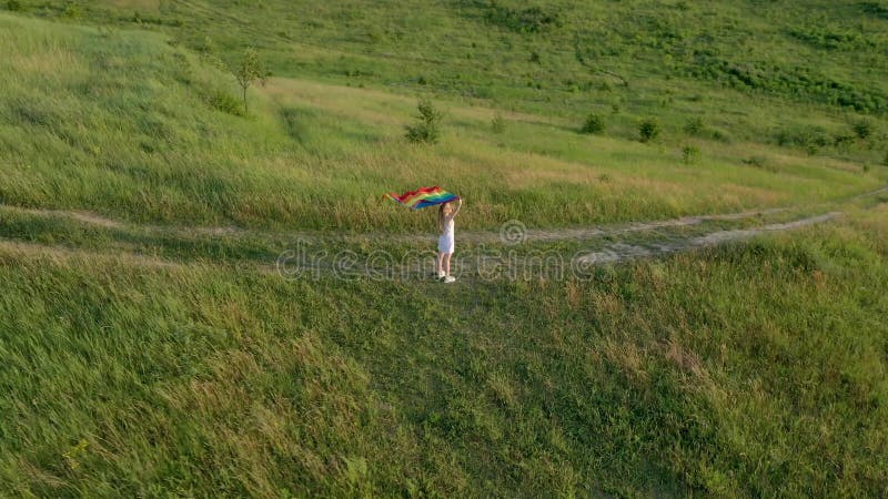 Lesbiana mujer con bandera lgbt en una montaña verde