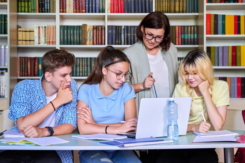 Lesson in Library, High School Teacher with Group of Teenagers Stock