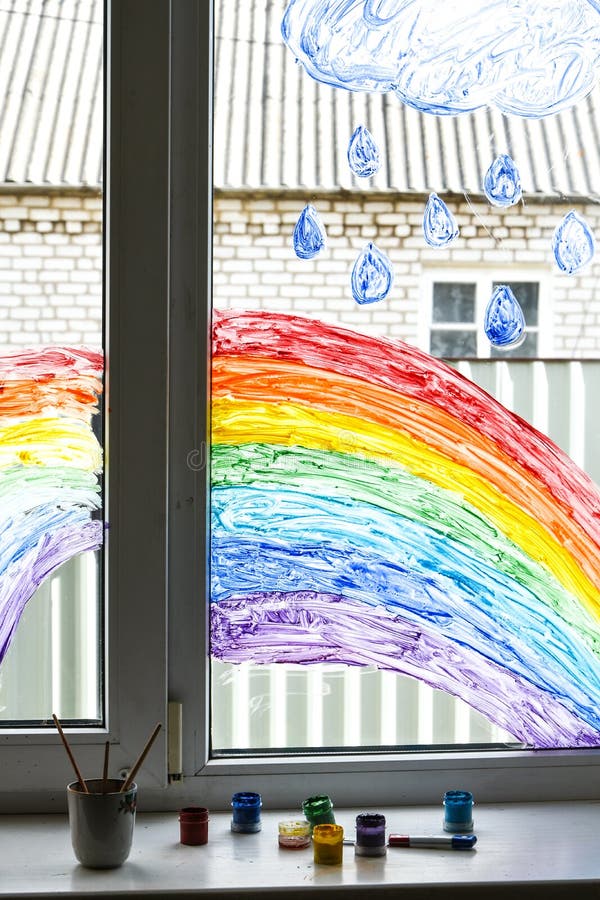 Let`s all be well. public flashmob children paint a rainbow on the windows waiting for the end of the quarantine pandemic