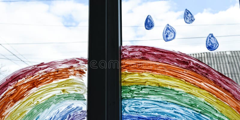 Let`s all be well. public flashmob children paint a rainbow on the windows waiting for the end of the quarantine pandemic