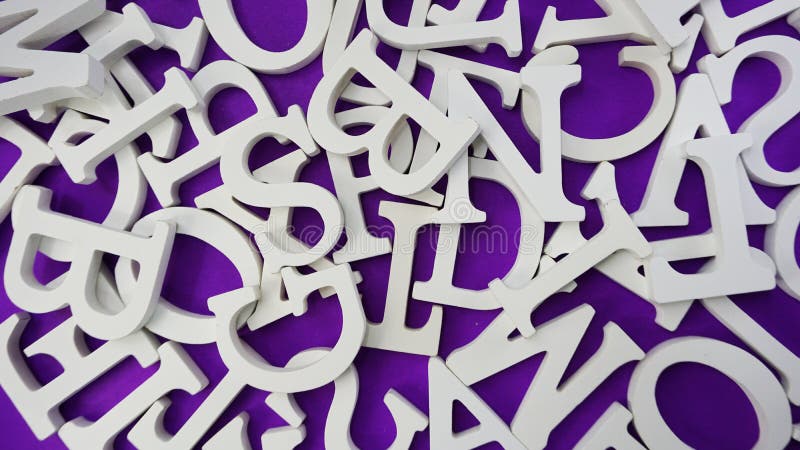 letras de madeira brancas aleatórias do alfabeto no fundo roxo imagens de stock letras de madeira brancas aleatórias do alfabeto no fundo roxo imagens de stock