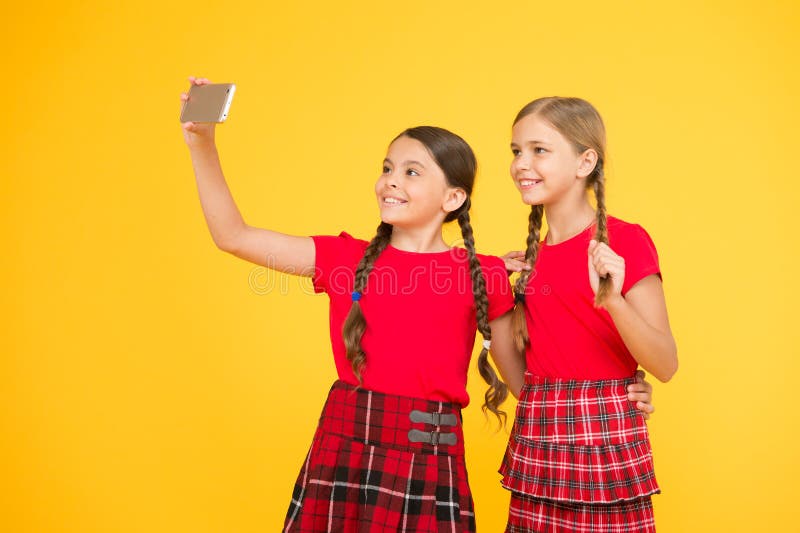 Lets hace imagen Muchachas en uniforme pequeñas muchachas que hacen el selfie en el teléfono Padre y ni?o que juegan junto herman fotos de archivo Lets hace imagen Muchachas en uniforme pequeñas muchachas que hacen el selfie en el teléfono Padre y ni?o que juegan junto herman fotos de archivo