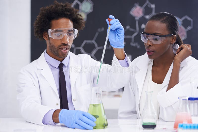 Lets hope it doesnt go KABOOM. two scientists conducting an experiment with various chemicals. royalty free stock images