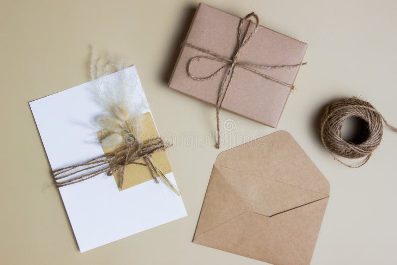 A letter concept with envelope and gift box and rope over the brown background. stock image