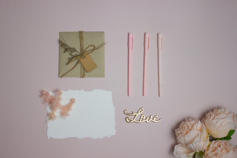 Letter concept with pink roses, pens, and a white letter on a pink background. royalty free stock photos