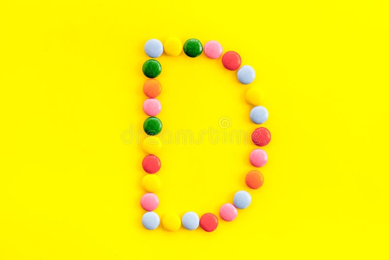 Letter D Alphabet Made with Sweets on Yellow from Above Stock Image