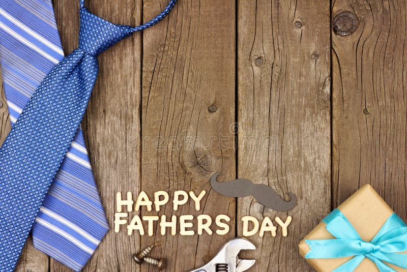 Happy Fathers Day wood letter greeting with tools and ties on a rustic wood background. Top view, corner border. Happy Fathers Day wood letter greeting with tools and ties on a rustic wood background. Top view, corner border.