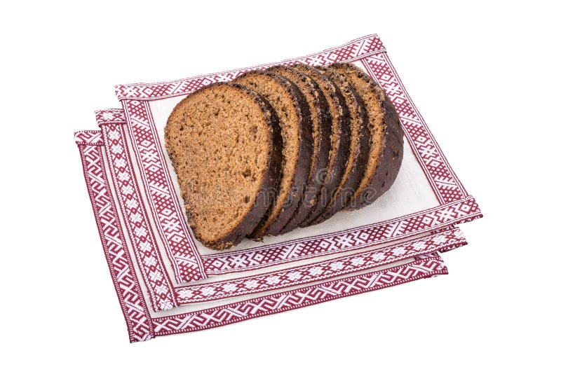 Slices of latvian rye bread on the national linen tablecloths isolated on white background. Slices of latvian rye bread on the national linen tablecloths isolated on white background