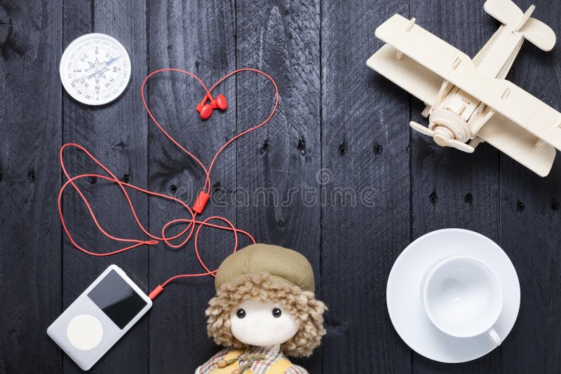 Lettore con il trasduttore auricolare rosso, tazza di caffè macchiato, aeroplano di legno immagini stock Lettore con il trasduttore auricolare rosso, tazza di caffè macchiato, aeroplano di legno immagini stock