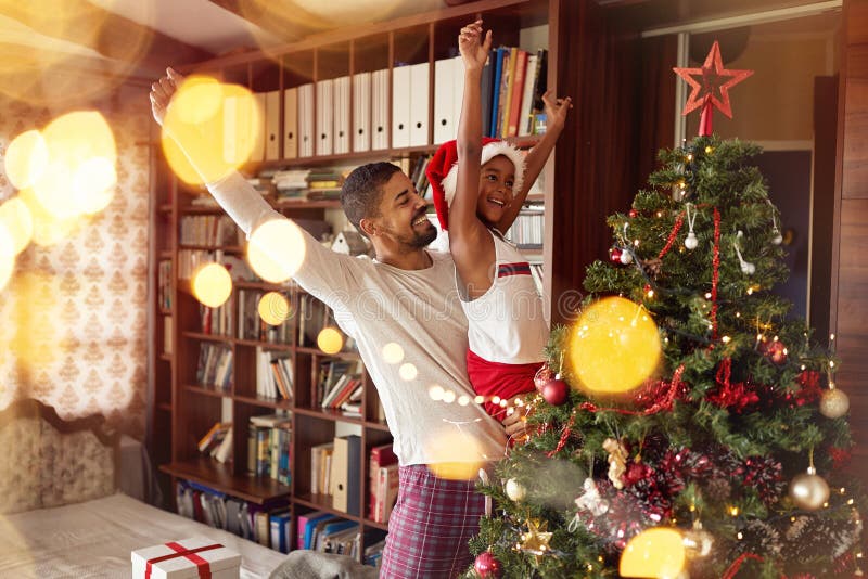 Leuk Afrikaans Amerikaans meisje die en Kerstboom spelen verfraaien stock fotografie Leuk Afrikaans Amerikaans meisje die en Kerstboom spelen verfraaien stock fotografie