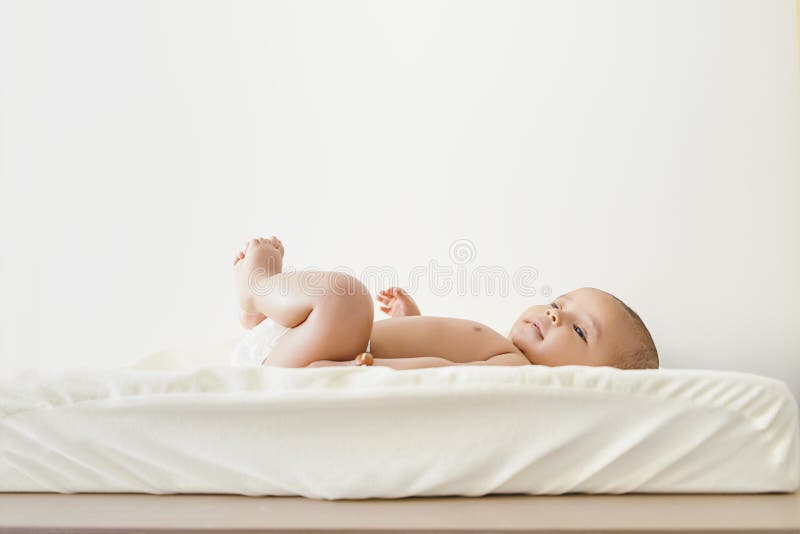 Leuk Babymeisje die in de Babywisselaar liggen stock afbeeldingen Leuk Babymeisje die in de Babywisselaar liggen stock afbeeldingen