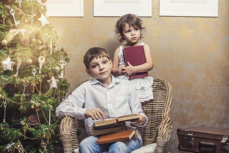 Leuk babysjongen en meisje als voorzitter die een boek in een binnenland lezen royalty-vrije stock afbeelding Leuk babysjongen en meisje als voorzitter die een boek in een binnenland lezen royalty-vrije stock afbeelding