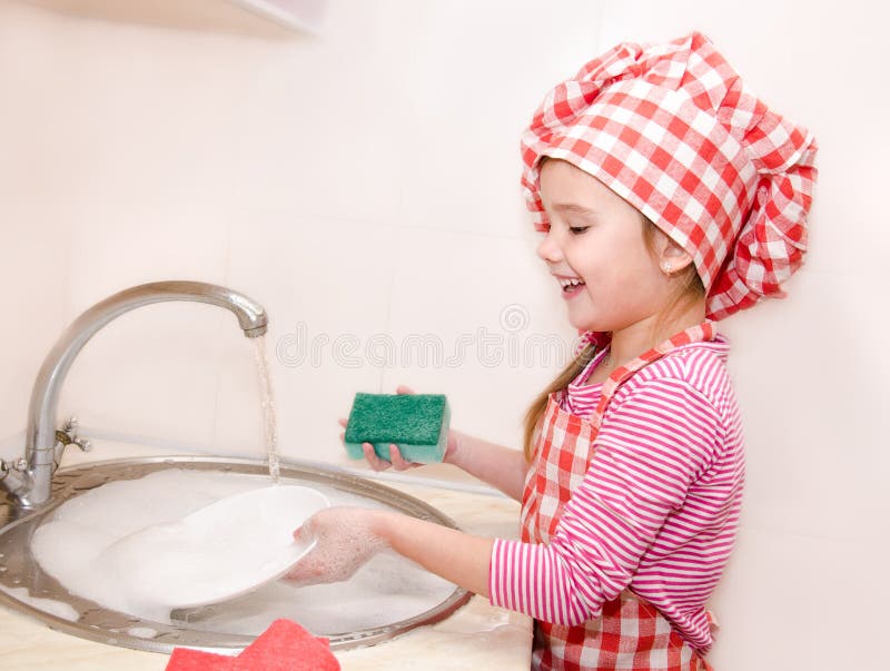 Leuk glimlachend meisje die de schotels wassen royalty-vrije stock fotografie Leuk glimlachend meisje die de schotels wassen royalty-vrije stock fotografie