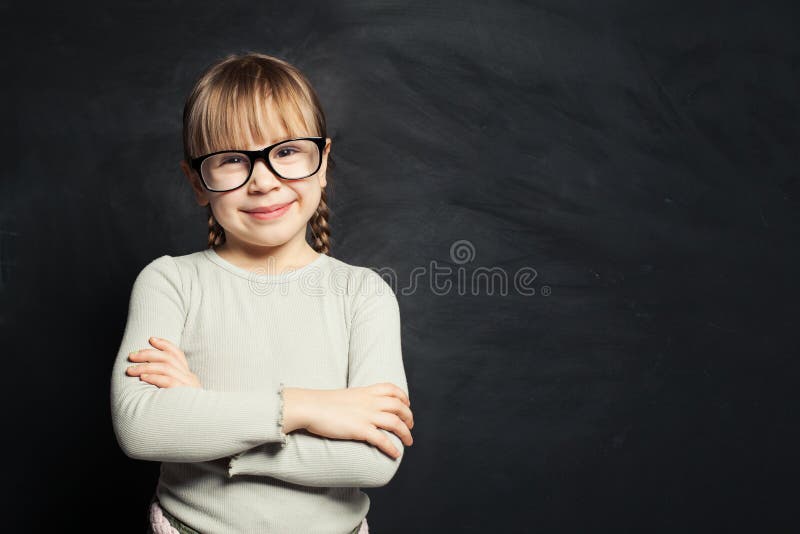 Leuk jong geitjeportret Gelukkig kindmeisje die en camera op de achtergrond van het schoolklaslokaal glimlachen bekijken royalty-vrije stock fotografie Leuk jong geitjeportret Gelukkig kindmeisje die en camera op de achtergrond van het schoolklaslokaal glimlachen bekijken royalty-vrije stock fotografie