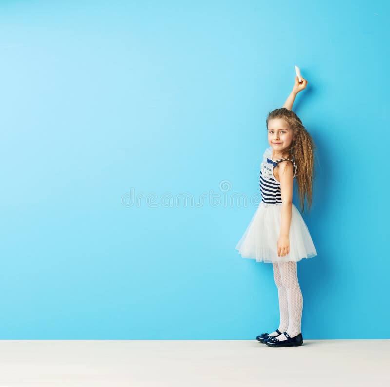 Leuk meisje die op de muur met krijt schrijven royalty-vrije stock afbeelding Leuk meisje die op de muur met krijt schrijven royalty-vrije stock afbeelding