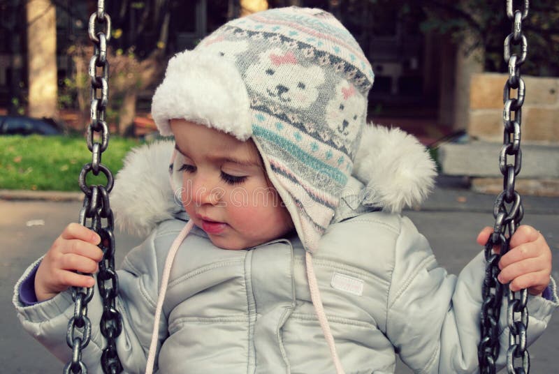 Leuk meisje op de schommeling in de winter; retro Instagram-stijl stock afbeeldingen Leuk meisje op de schommeling in de winter; retro Instagram-stijl stock afbeeldingen