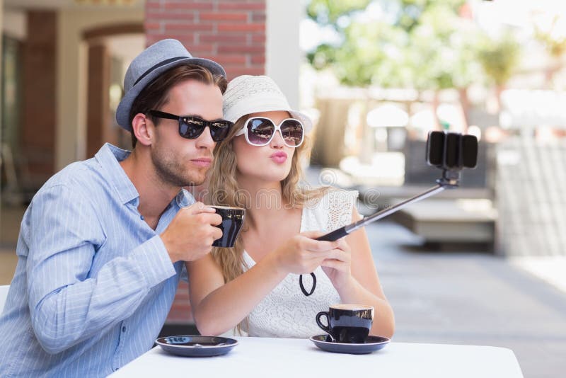 Leuk paar die een selfie met selfiestok nemen stock foto's Leuk paar die een selfie met selfiestok nemen stock foto's