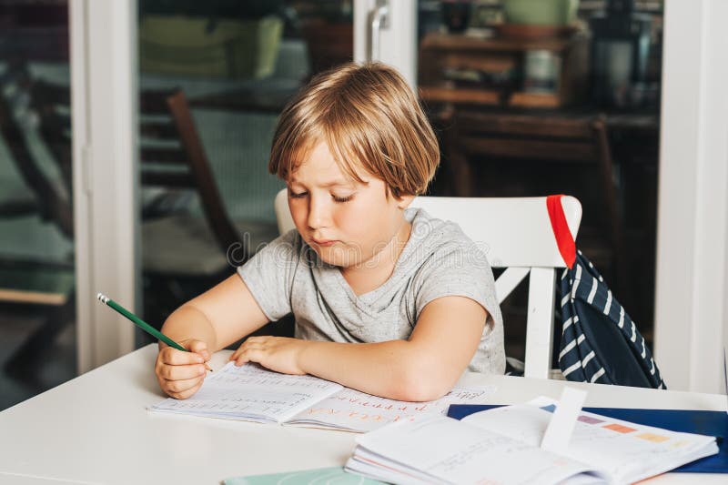 Leuk weinig jongen die thuiswerk voor school doen royalty-vrije stock afbeeldingen Leuk weinig jongen die thuiswerk voor school doen royalty-vrije stock afbeeldingen