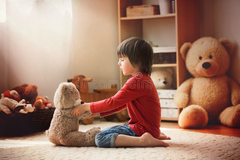 Leuk weinig kind, peuterjongen, die met teddybeer bij hom spelen stock afbeeldingen Leuk weinig kind, peuterjongen, die met teddybeer bij hom spelen stock afbeeldingen