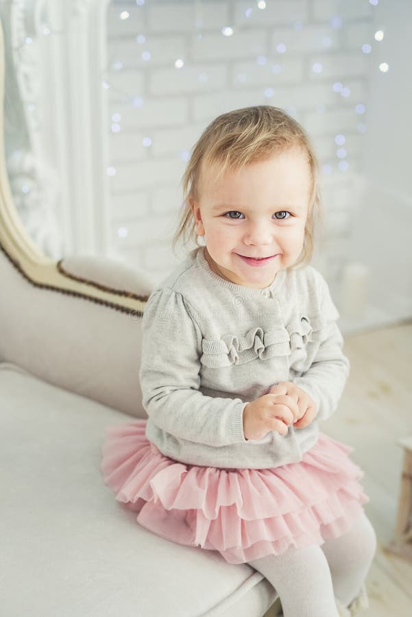 leuk weinig kindzitting als voorzitter dichtbij Kerstboom Gelukkig Nieuwjaar Het meisje van het portret Kerstmistak en klokken royalty-vrije stock afbeeldingen leuk weinig kindzitting als voorzitter dichtbij Kerstboom Gelukkig Nieuwjaar Het meisje van het portret Kerstmistak en klokken royalty-vrije stock afbeeldingen