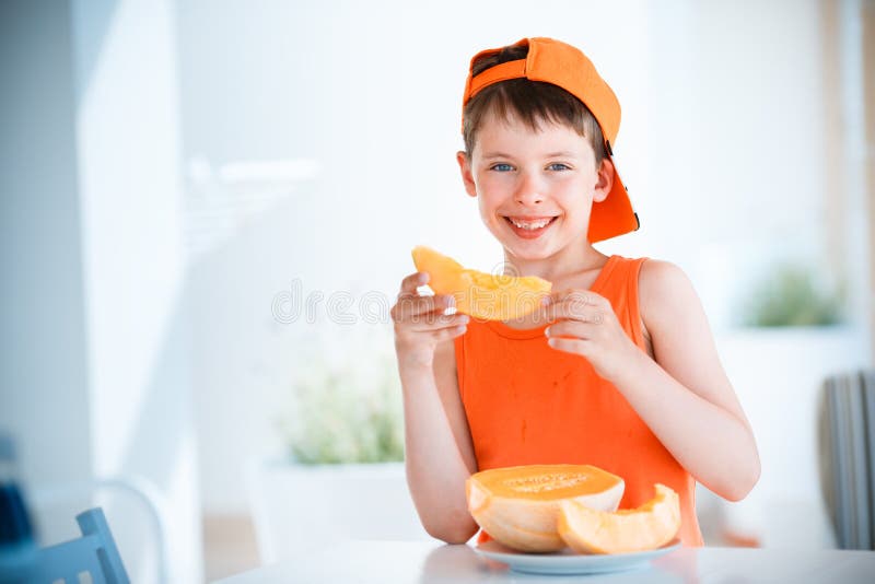 Leuk weinig meloen van de jongensholding gesneden oranje kantaloep in handen stock foto's Leuk weinig meloen van de jongensholding gesneden oranje kantaloep in handen stock foto's