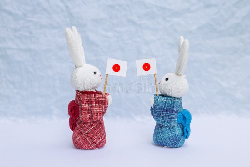Leuk weinig pop van het stoffenkonijn in de rode en blauwe traditionele Japanse vlag van Japan van de kledingsholding over vage w royalty-vrije stock fotografie Leuk weinig pop van het stoffenkonijn in de rode en blauwe traditionele Japanse vlag van Japan van de kledingsholding over vage w royalty-vrije stock fotografie