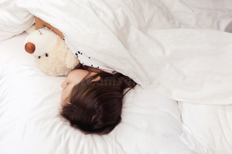 Leuk weinig slaap van het kindmeisje met teddybeer stock foto Leuk weinig slaap van het kindmeisje met teddybeer stock foto